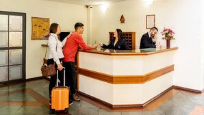 A hotel reception area with a reception desk, a map on the wall, and a clock. - Itapetinga Hotel (Atibaia)