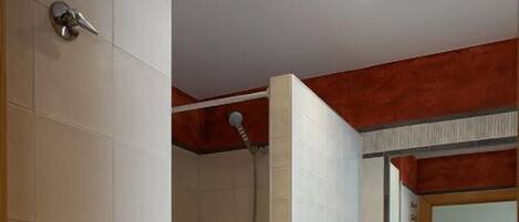 A bathroom with a shower, a sink, and a mirror.