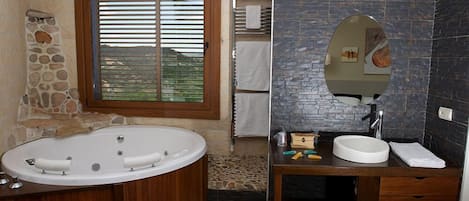 A bathroom with a stone wall, a wooden bathtub, a sink with a mirror, and a window with blinds.