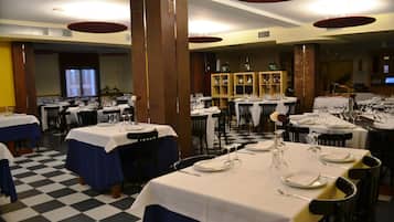 Un restaurante con varias mesas dispuestas para comer, que presenta un suelo a cuadros y diferentes tipos de decoración de mesa.