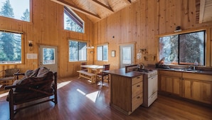 A spacious wooden cabin with a kitchen, dining area, and a cozy seating area. - Silver City Mountain Resort (Three Rivers)