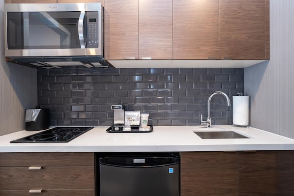 Una cucina moderna con forno a microonde integrato, macchina del caffè e lavastoviglie.