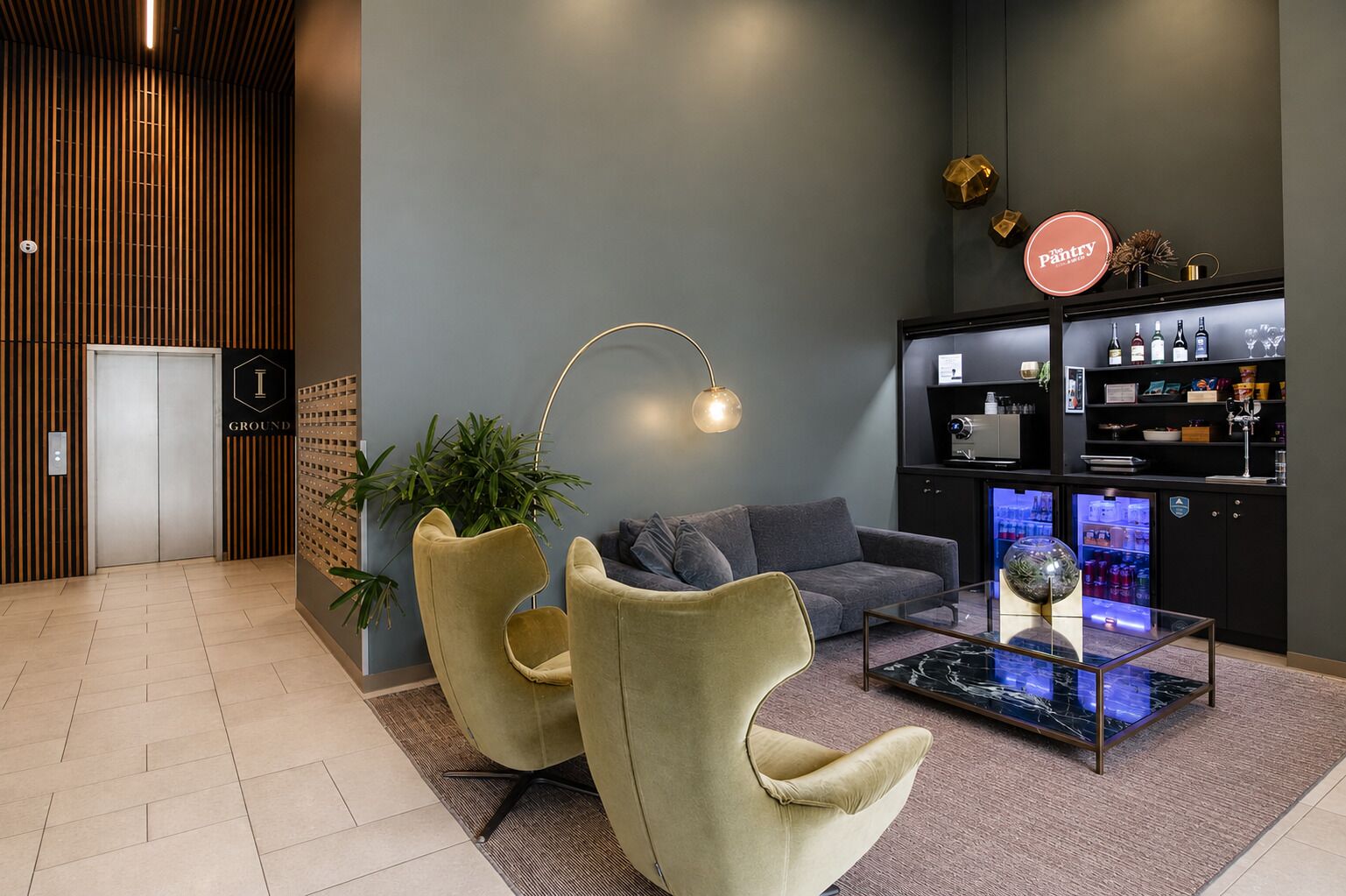 A modern lobby with a reception desk, seating area, and a minibar.
