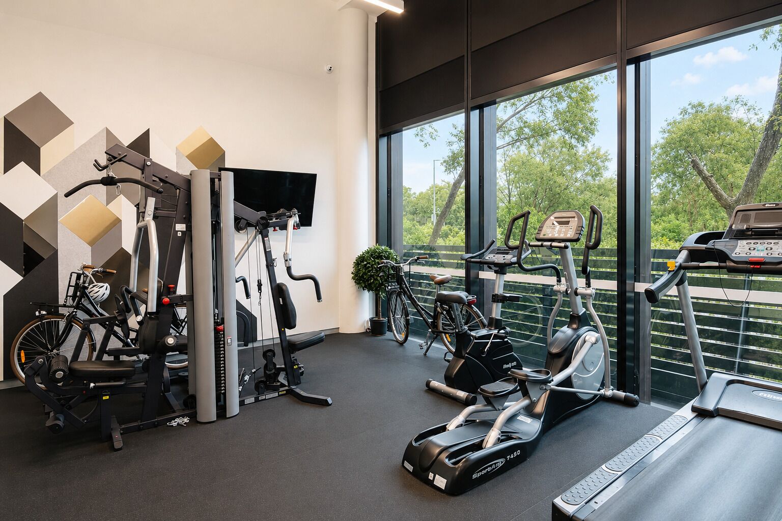 A gym with various exercise equipment, including a treadmill, stationary bikes, and weight machines.