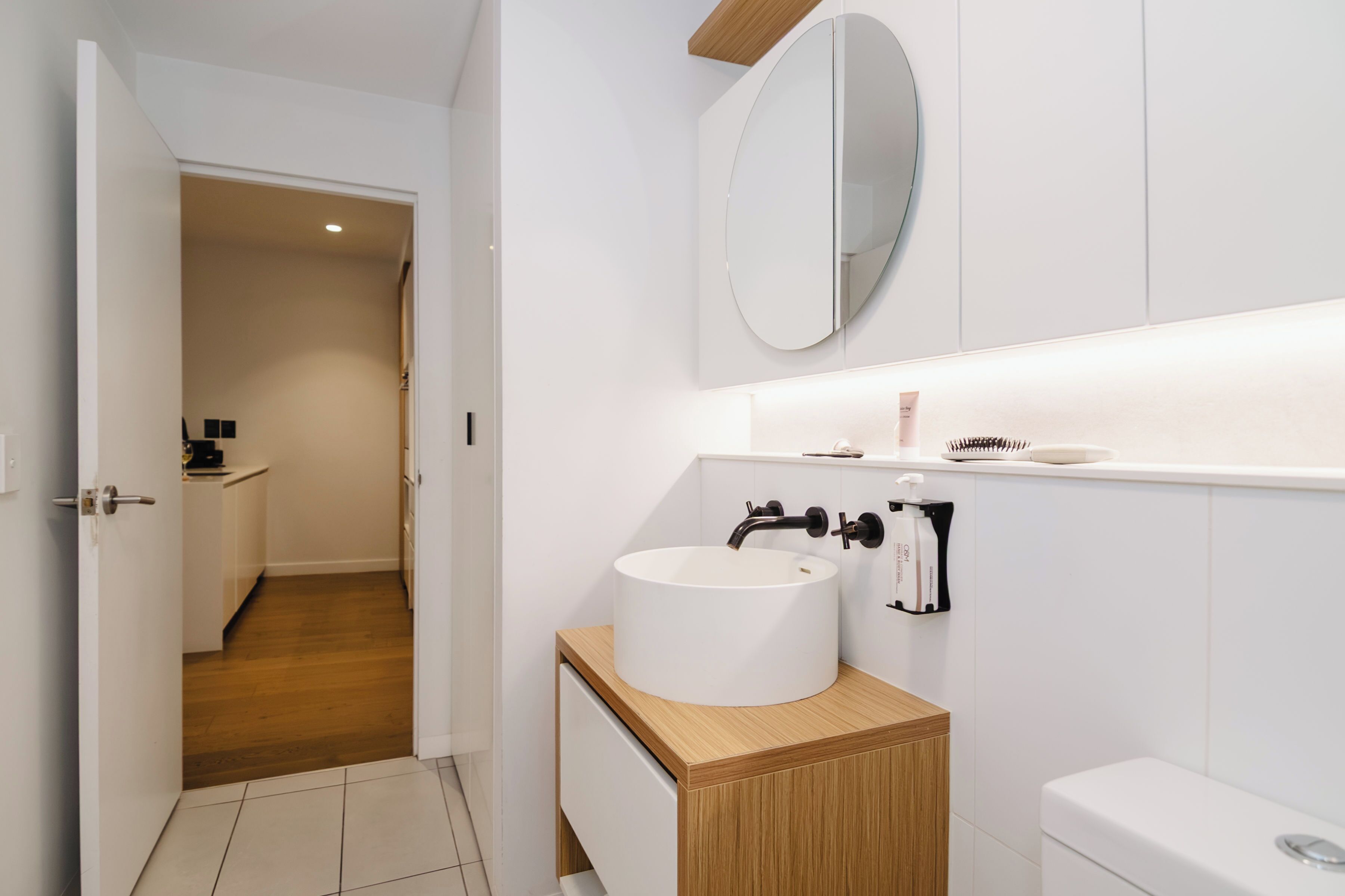 Ein modernes Badezimmer mit Waschbecken, Spiegel und Toilette.