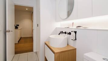 Ein modernes Badezimmer mit Waschbecken, Spiegel und Toilette.
