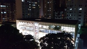 Un edificio de gran altura con varios pisos, cada uno con ventanas iluminadas.