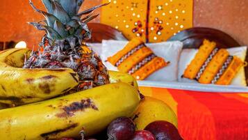 Un piatto decorativo con un vassoio di frutta, banane, uva e un'ananas.