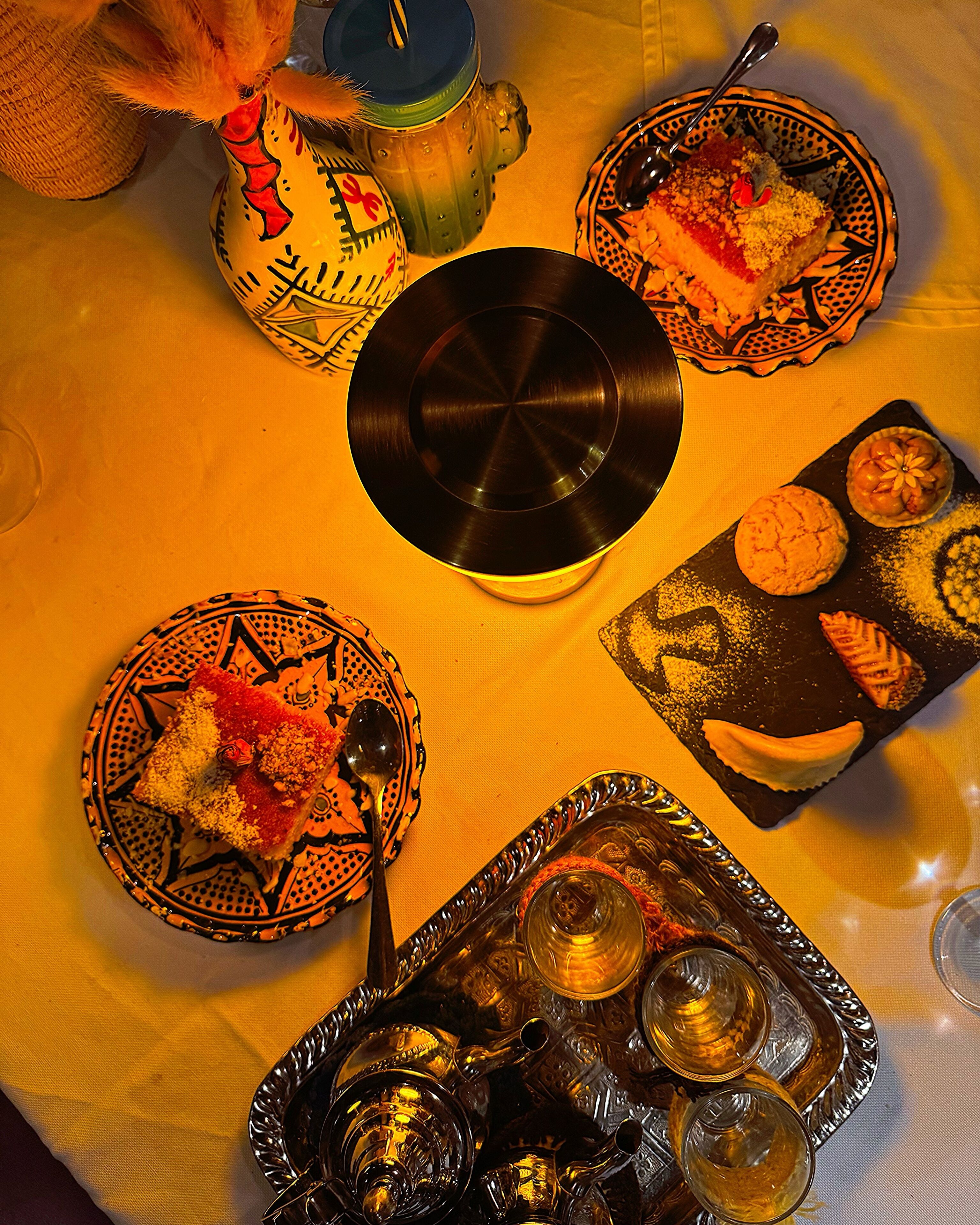 Una mesa con diversos platos, un disco de vinilo y una bandeja de vasos.