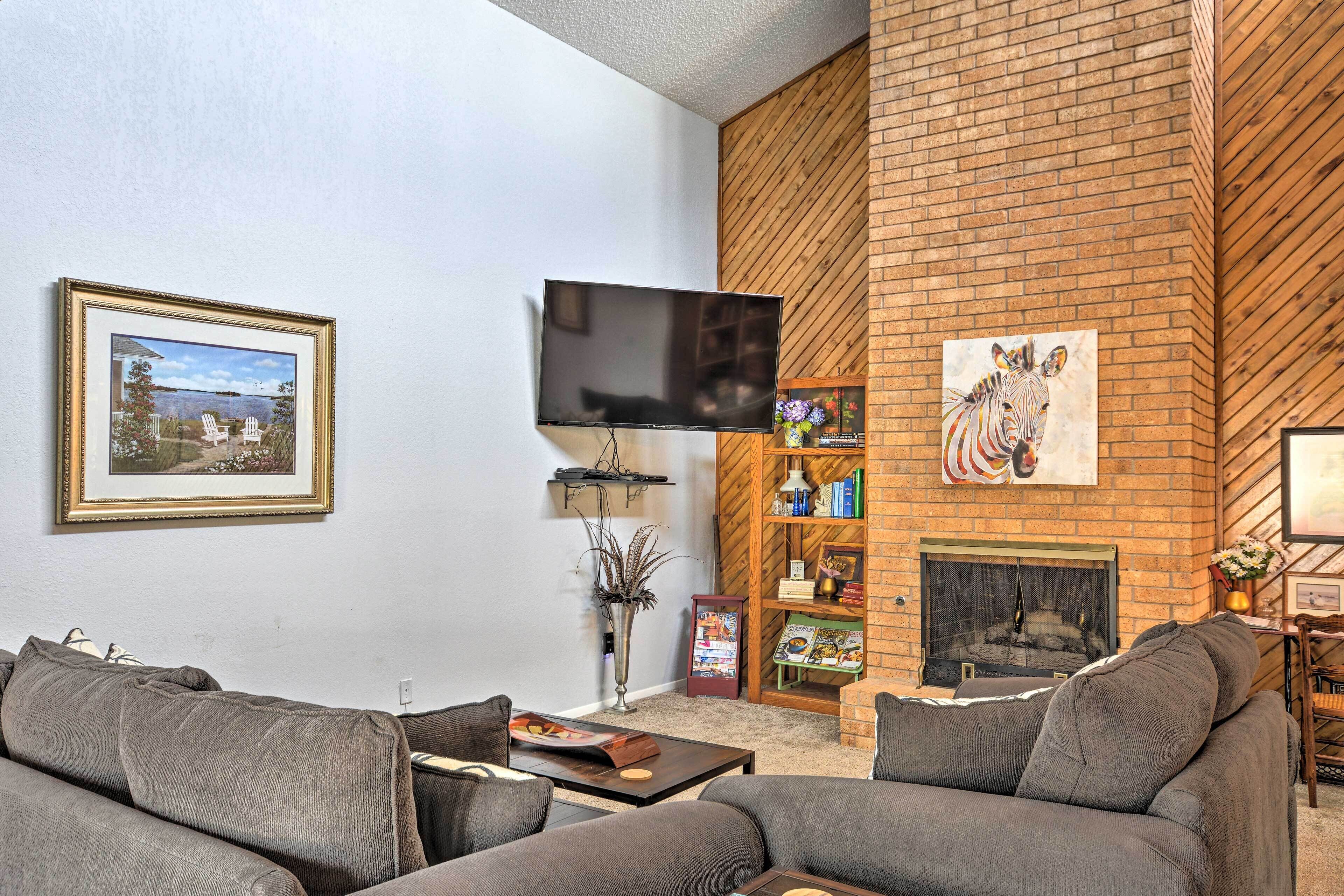 A living room with a fireplace, a flat-screen TV, and a bookshelf.