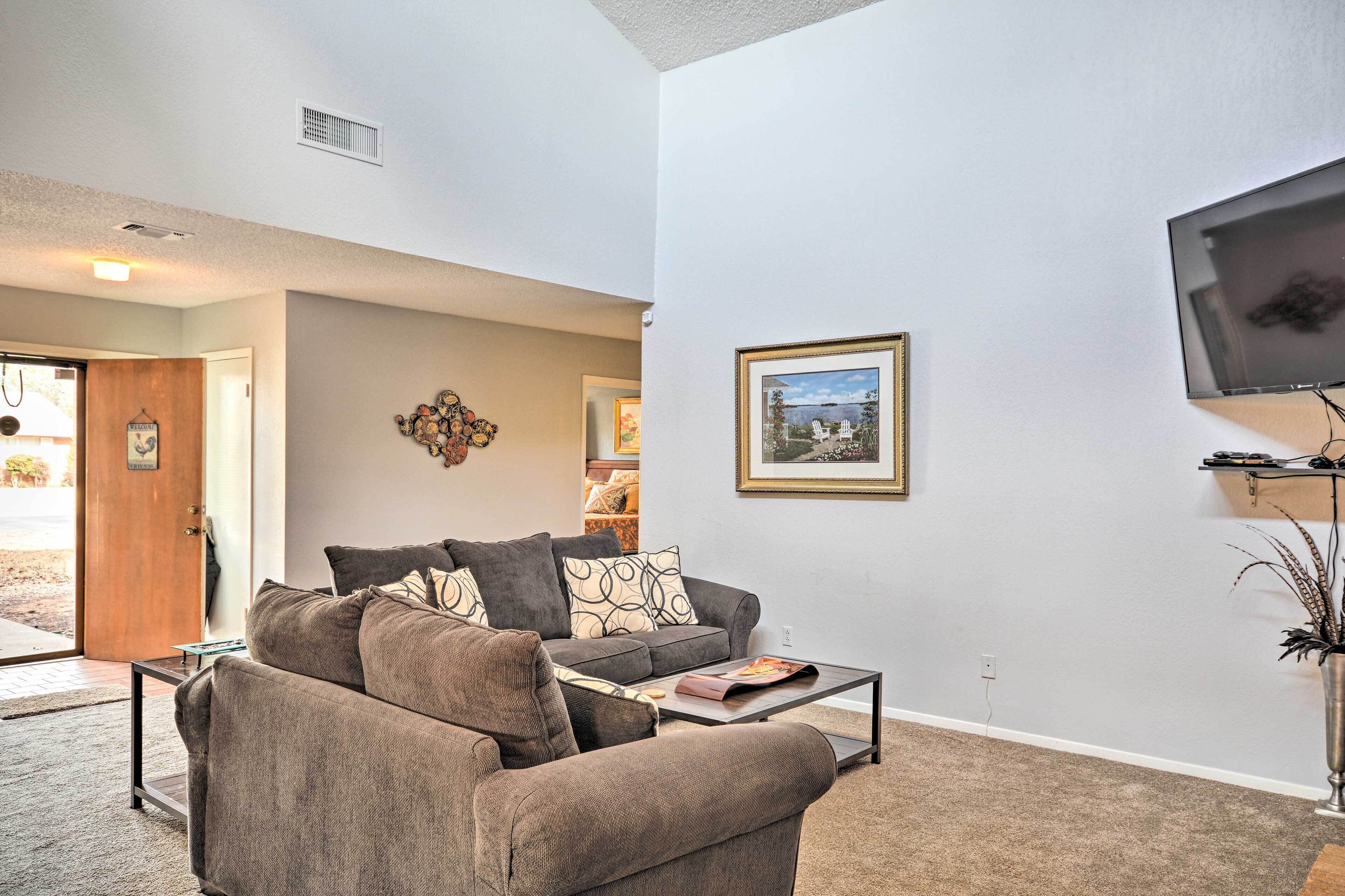 A living room with a sofa, coffee table, and a mounted TV.