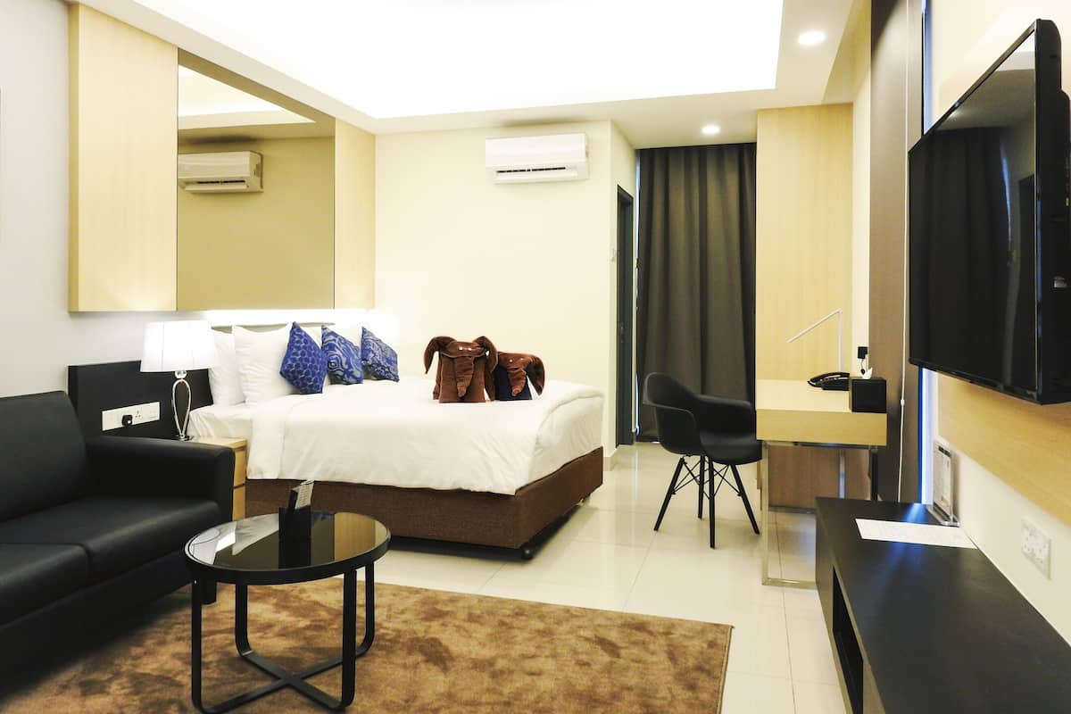 Une chambre d’hôtel moderne équipée d’un lit, d’un canapé, d’un bureau, d’une télévision et d’un appareil de climatisation.