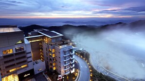 Un hôtel moderne à plusieurs étages, doté d’une terrasse sur le toit et offrant une vue sur les montagnes environnantes.