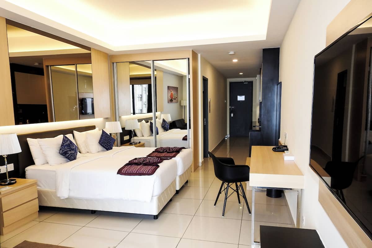 Une chambre d’hôtel moderne, dotée d’un grand lit, d’un bureau et d’une télévision.