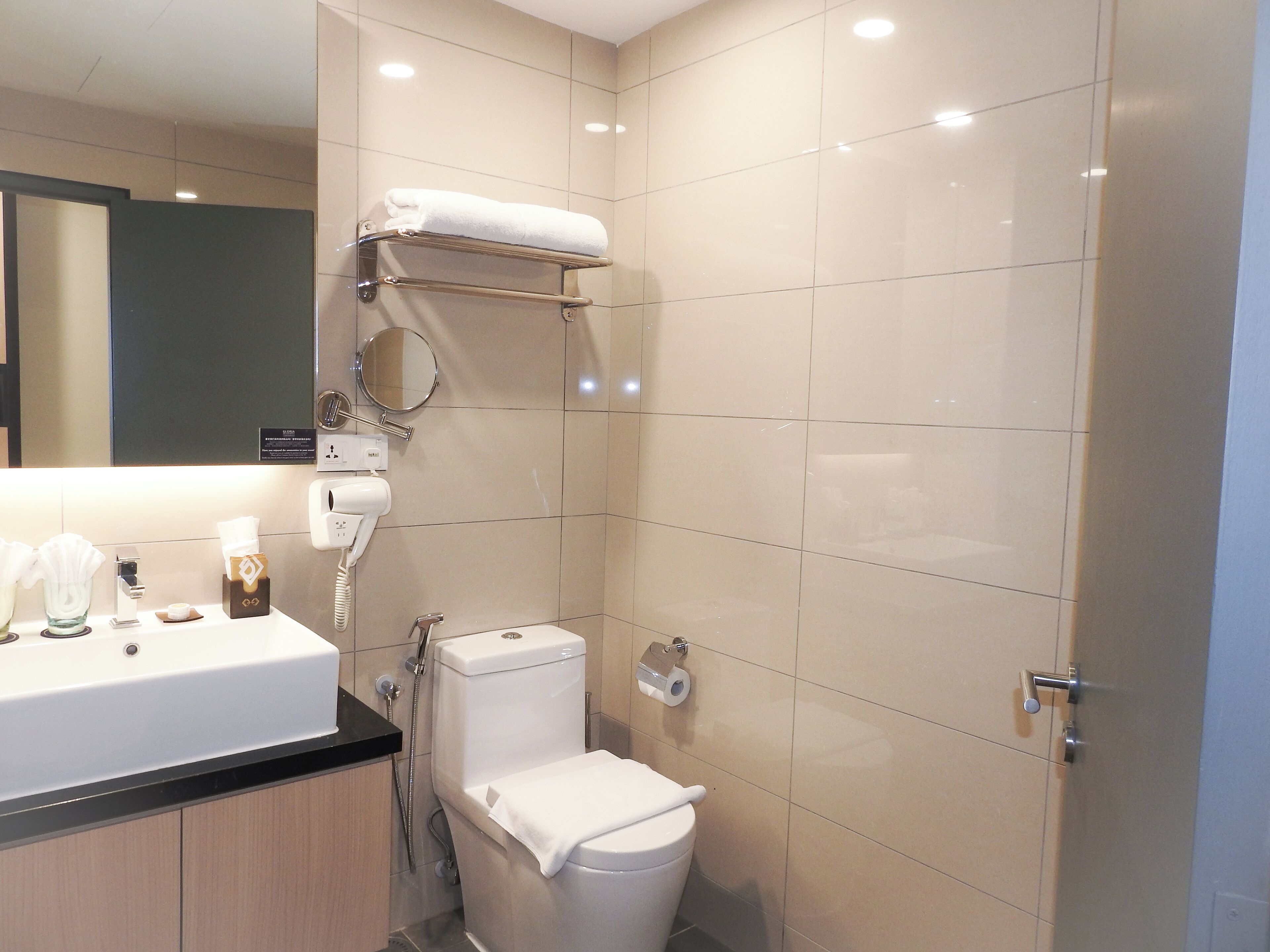 Ein modernes Badezimmer mit Toilette, Waschbecken und Handtuchhalter.