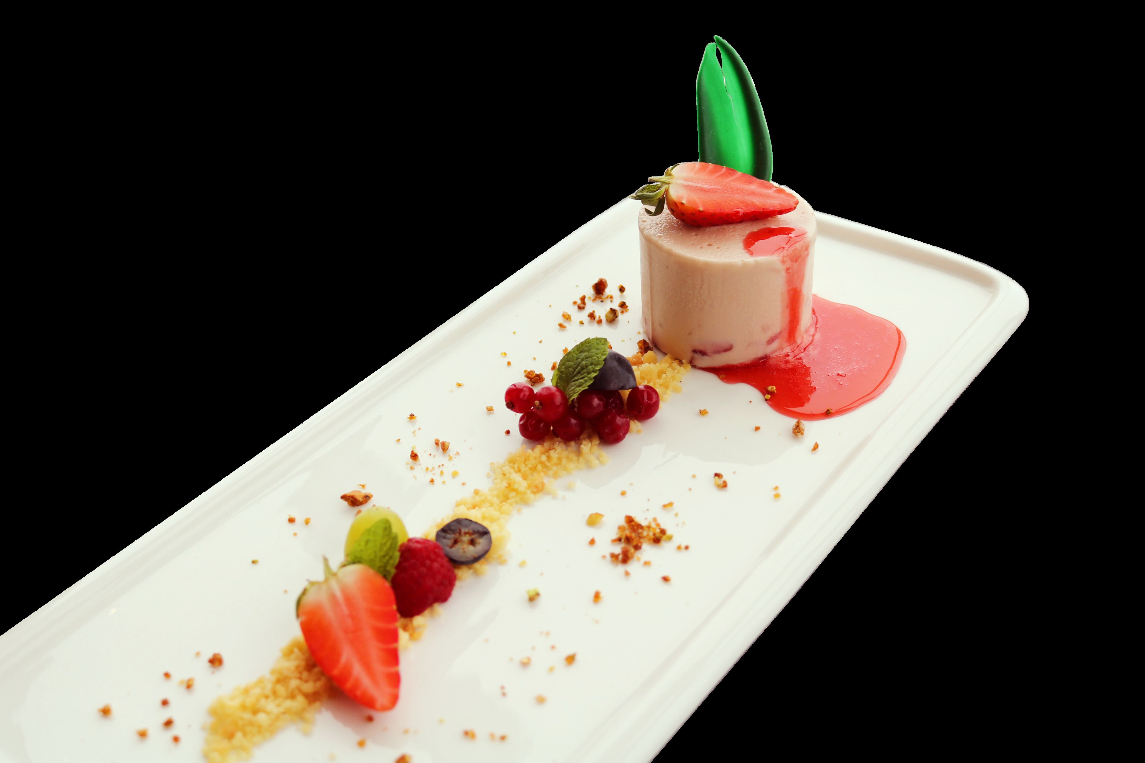 A dessert on a white rectangular plate with strawberries, raspberries, and a green leaf garnish.