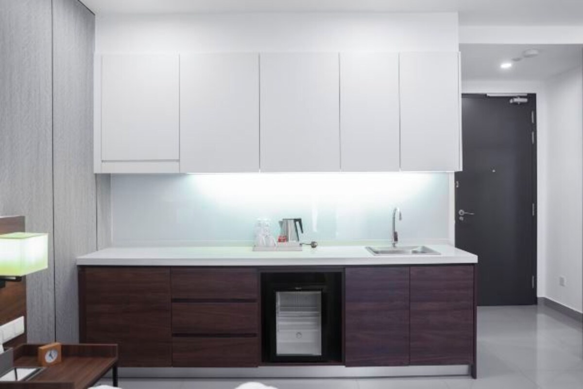 Een moderne keuken met witte kastjes, een inbouwvaatwasser en een aanrecht met een spoelbak.