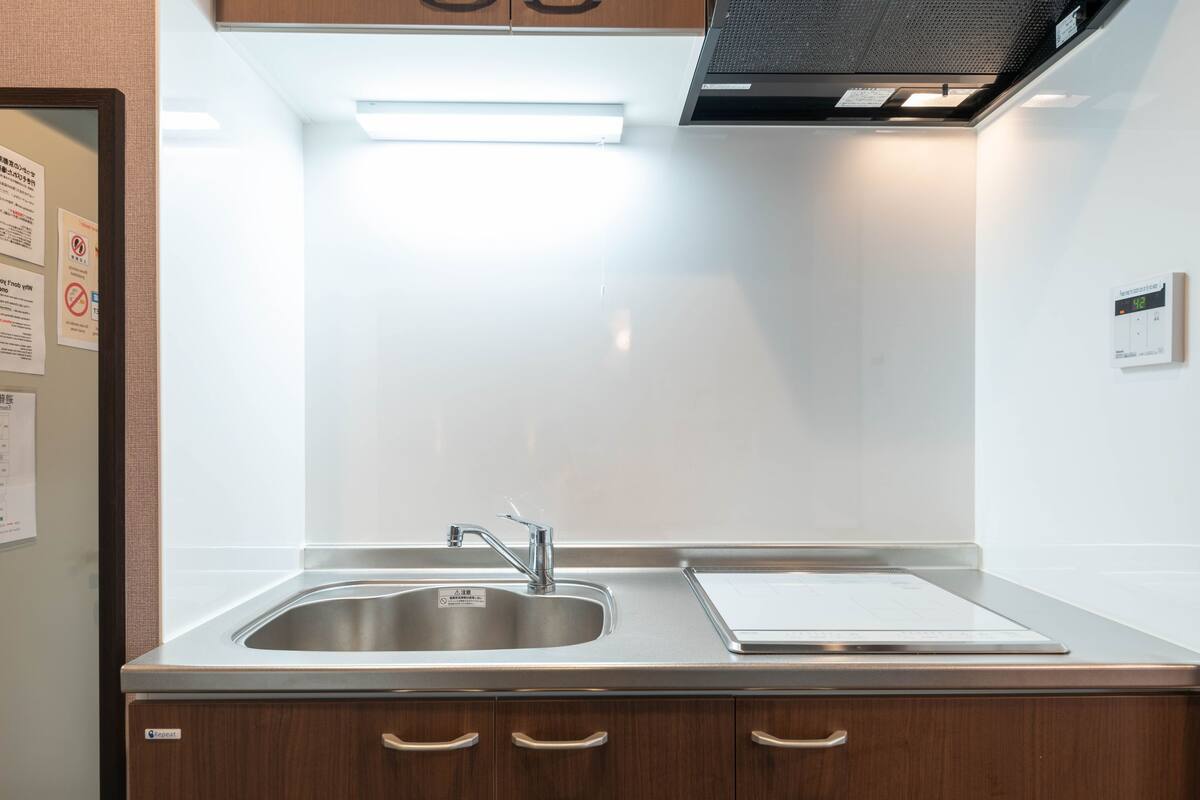 Una cocina moderna con electrodomésticos de acero inoxidable, un lavamanos doble y armarios de madera.