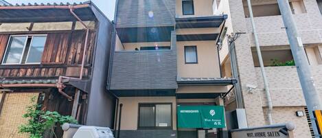 Un edificio de varios pisos con un letrero que dice 'Guesthouse Kyoto West Avenue Salin'.