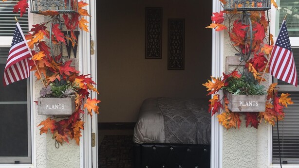 A bedroom with a bed, a ceiling fan, and a window with blinds.
