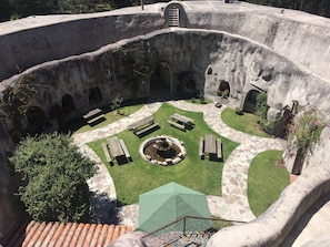 A courtyard with stone walls, a fire pit, and outdoor seating. - Hacienda Las Cuevas Terra Lodge (Pifo)