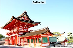 A traditional Japanese building with a multi-tiered roof and red and white walls.