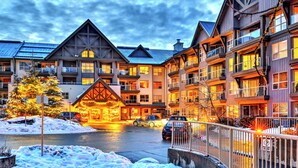 A multi-story hotel with a traditional architectural style, featuring balconies and large windows. - Aspens #113 Prime Ski-in Ski-out Location! Pool, Hot tubs, BBQ, sleeps 4 (Whistler)