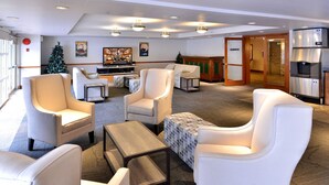 A spacious lobby with multiple seating areas, a fireplace, and a kitchen area. - Aspens #113 Prime Ski-in Ski-out Location! Pool, Hot tubs, BBQ, sleeps 4 (Whistler)