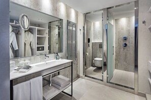 A modern bathroom with a glass-enclosed shower, a large mirror, and a vanity with a sink and towel rack. - Catalonia Royal Ses Estaques (Santa Eulalia del Rio)