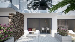 Un espace piscine extérieur moderne, agrémenté de murs en pierre, de mobilier blanc et de plantes tropicales.