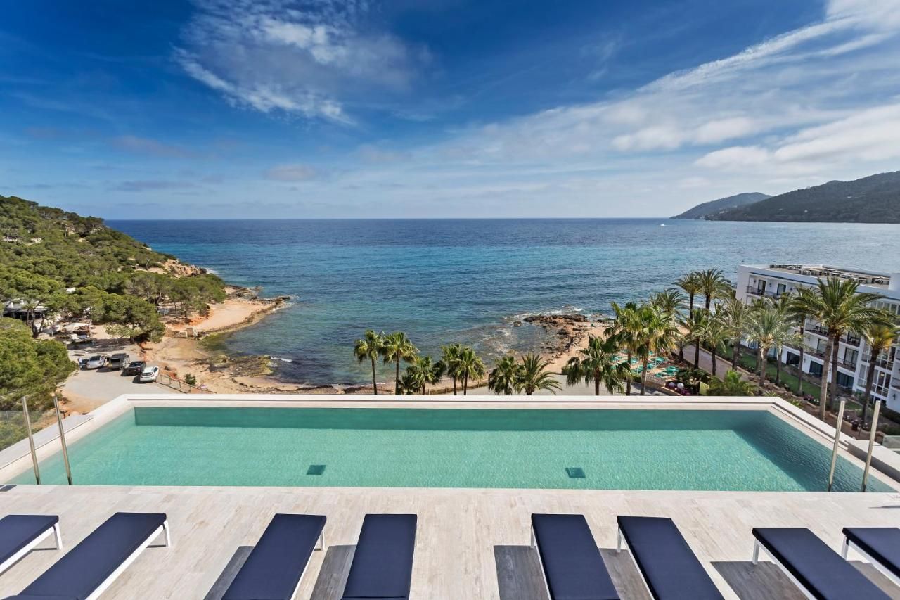 A pool with a view of the sea and a beach.