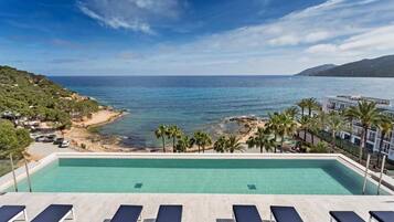 A pool with a view of the sea and a beach.