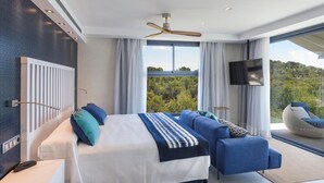 Une chambre moderne avec un grand lit, un canapé et une télévision.