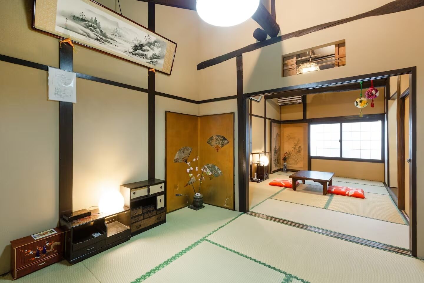 A traditional Japanese room with tatami flooring, a shoji screen, and a low table.