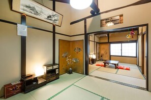 Een traditionele Japanse kamer met tatami vloerbedekking, een shoji scherm en een lage tafel.