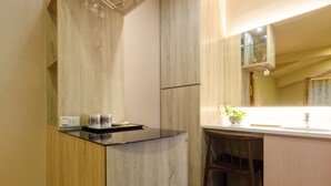 Una cocina moderna con encimera negra, armarios de madera y un taburete pequeño.