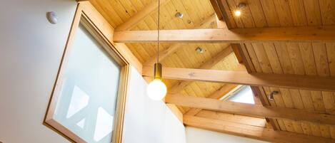 A high ceiling with wooden beams and a skylight.