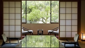 A traditional Japanese room with tatami flooring, a low table, and sliding doors. - Dogo Onsen Hotel Tsubakikan (Matsuyama)
