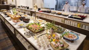 A buffet with various dishes and a kitchen in the background. - Dogo Onsen Hotel Tsubakikan (Matsuyama)