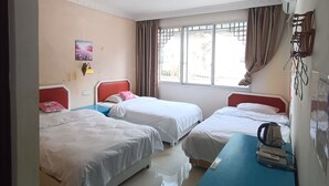A hotel room with two beds, a blue desk, a kettle, and a window with curtains. - How Flower Hostel Yangshuo (Guilin)