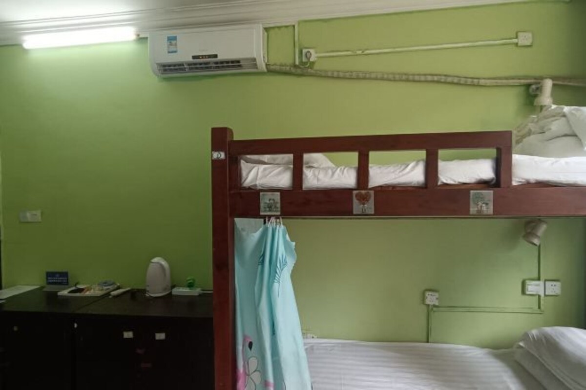 A bunk bed room with a desk, a chair, and a small table.