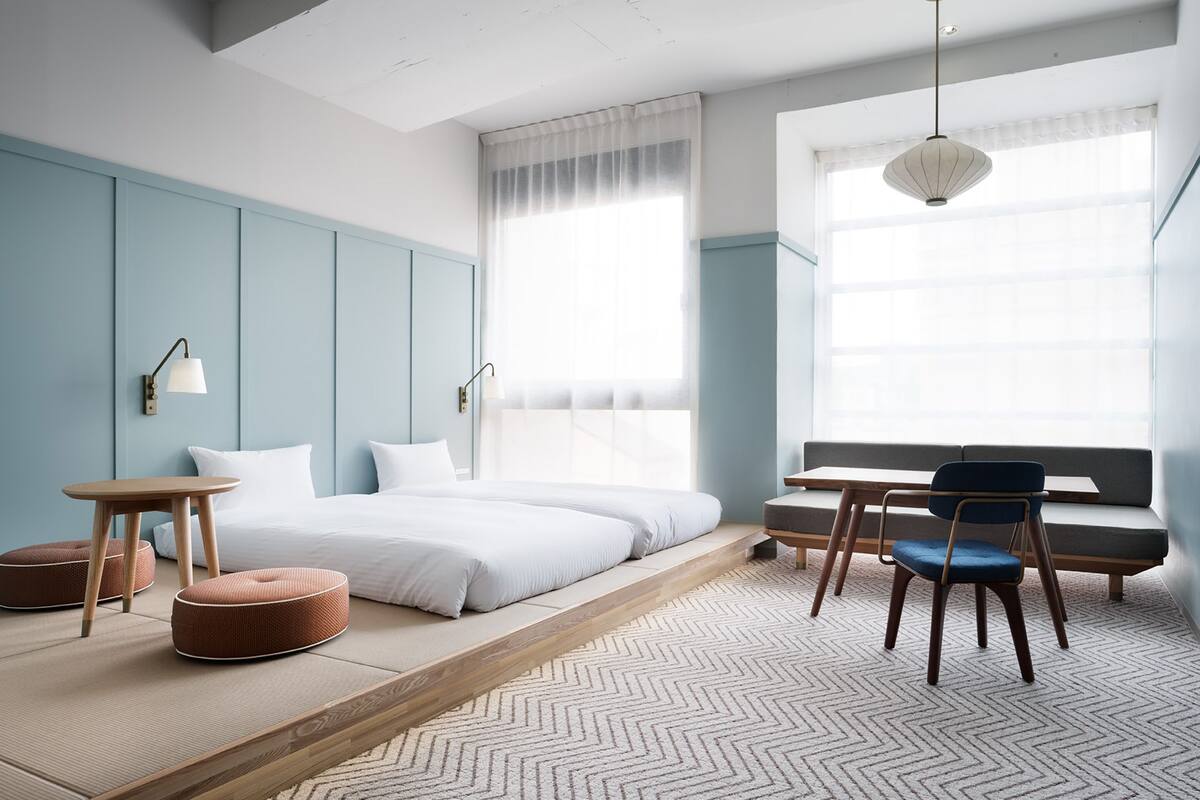 A modern bedroom with a bed, a desk, and a chair.