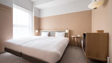 Une chambre d’hôtel avec un grand lit, des tables de chevet, un bureau et une lampe.