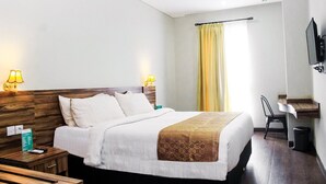 A hotel room with a bed, bedside lamps, a desk, a chair, and a TV. - Azza Hotel Palembang by Horison (Palembang)