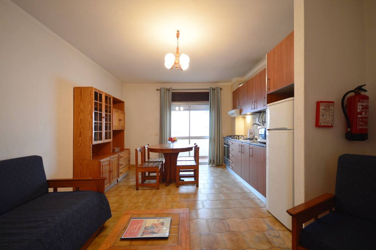 A compact living space with a dining area, kitchenette, and seating area.