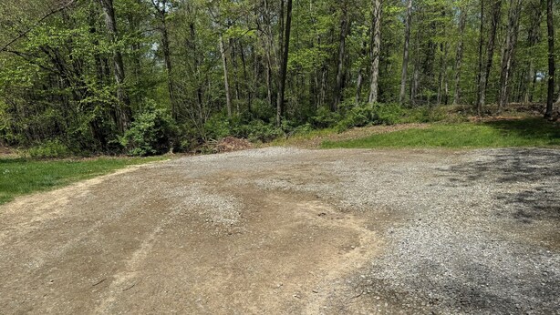 Un sentier de gravier qui serpente à travers une zone boisée.