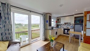 Una cocina moderna con comedor, grandes puertas correderas de vidrio y vistas al exterior.
