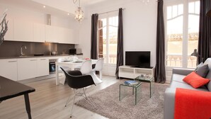 A modern apartment with a kitchen, dining area, living room, and balcony.