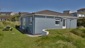 A small, single-story house with a sloped roof, a front porch, and a small attached garage.