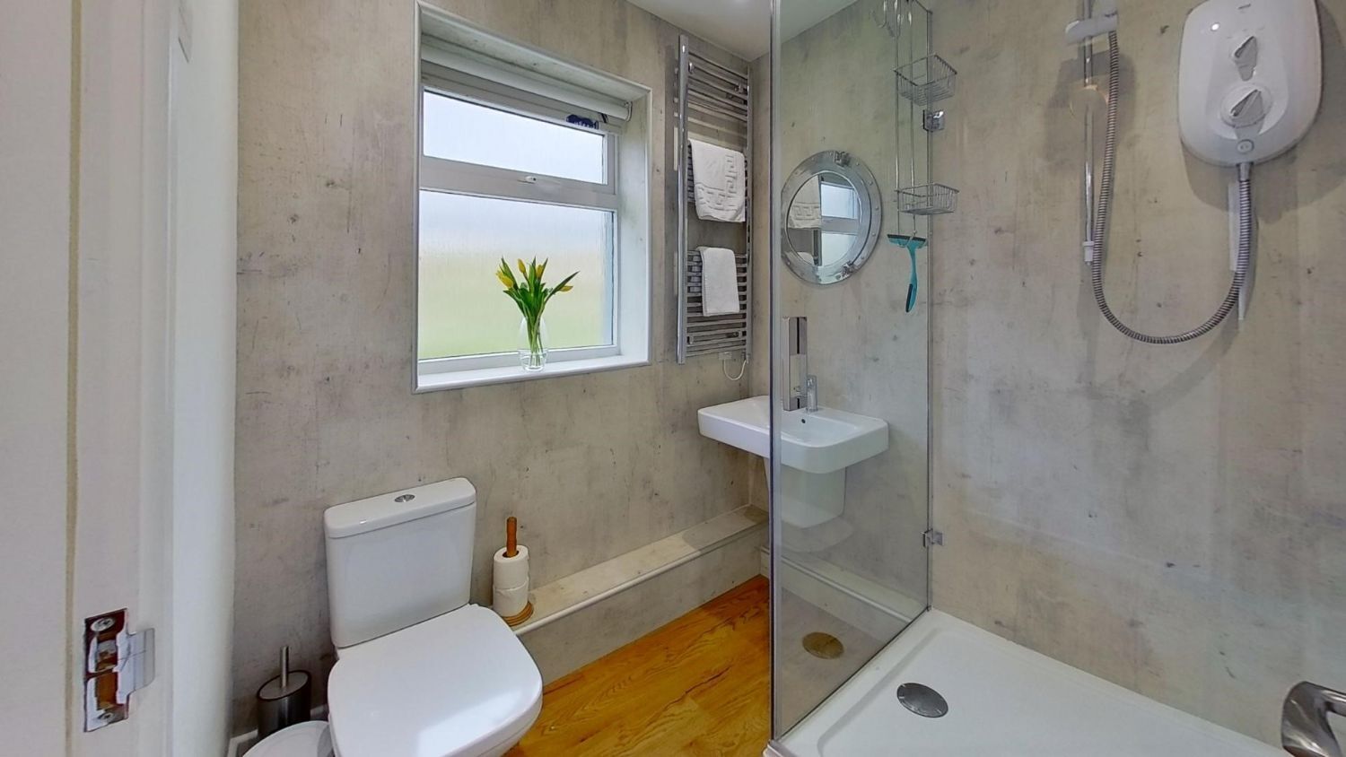 Een badkamer met toilet, wastafel en douche.